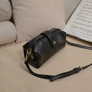 Close-up detail of a vintage black leather frame doctor bag with elegant gold hardware.