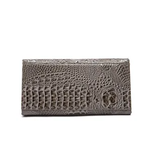 Vista detallada de un bolso de mano retro para mujer en piel con relieve de cocodrilo marrón
