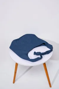 Detalle de un elegante bolso hobo de mezclilla azul con un asa anudada única