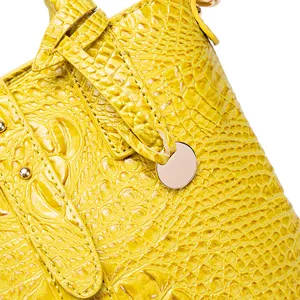 Primer plano de la textura de cocodrilo amarilla y herrajes dorados en bolso vintage
