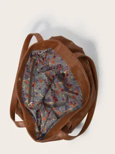 Vista detallada del interior de un bolso tote de cuero marrón con forro floral