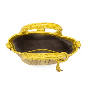 Vista interior detallada de un bolso vintage amarillo con relieve de cocodrillo y asas