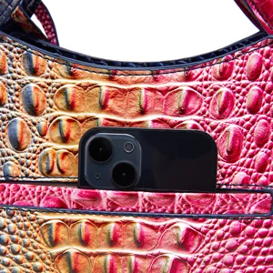 Detalle de bolso multicolor con relieve de cocodrilo y bolsillo para móvil