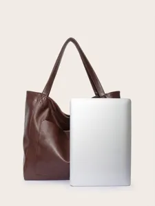 Bolso tote vintage de cuero encerado mostrado con laptop para una comparación tamaño