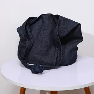 Primer plano de bolso bandolera vaquero azul oscuro vintage con detalle de nudo