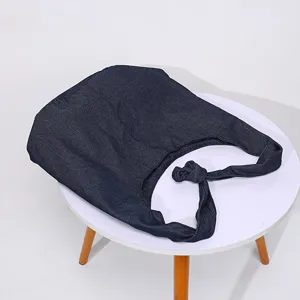 Bolso de hombro vintage de algodón y lino azul marino sobre una mesa redonda blanca