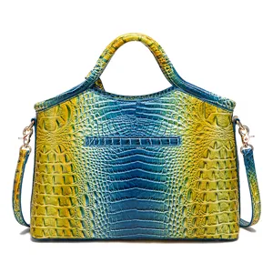 Vista frontal de un bolso de mano con relieve de cocodrilo y degradado azul y amarillo