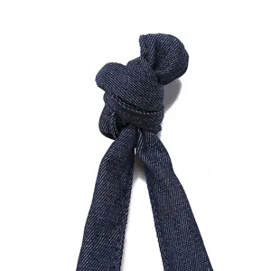 Primer plano del detalle de la correa anudada en un bolso de lona azul marino vintage