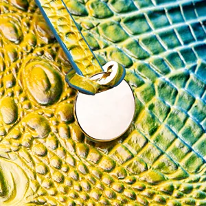 Primer plano de cuero con relieve de cocodrilo degradado amarillo y azul con placa