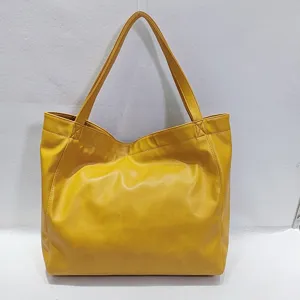 Vista detallada del bolso tote amarillo vintage de cuero encerado con textura suave
