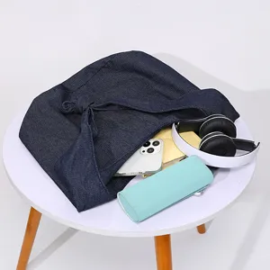 Bolso tote vintage de mezclilla azul marino y lino con accesorios en mesa blanca