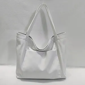 Vista detallada del bolso tote grande de cuero suave blanco con bolsillo frontal