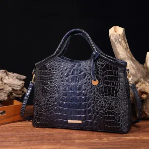 Elegante bolso de mano azul marino brillante con patrón de cocodrilo y detalles oro.