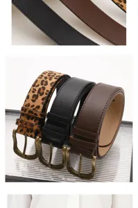 Macro shot of vintage leopard and solid color leather belts with antique bronze buckles.