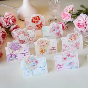 Set of watercolor floral greeting cards with sweet English wishes on elegant desk
