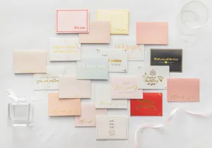 Colección variada de pequeñas tarjetas de felicitación plegables con letras en pan de oro