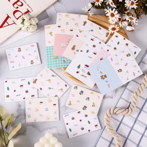 Multiple cute cartoon animal message cards with teddy bear and bunny patterns on a table