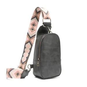 Detalle de bolso de pecho retro gris con correa tejida geométrica rosa y beige claro