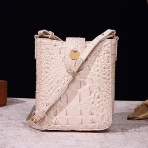 Detalle de bolso bandolera crema con textura de cocodrilo y herrajes dorados vintage