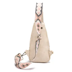 Detalle de un bolso bandolera beige para mujer con correa ancha de estilo bohemio.