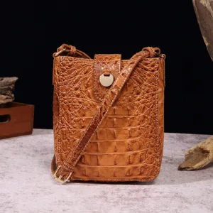 Vista detallada de un bolso bandolera retro para móvil en marrón con relieve de cocodrilo