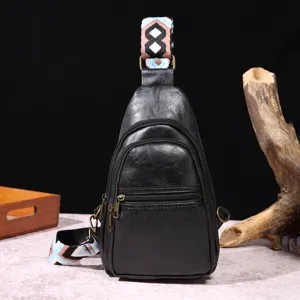 Detalle del bolso de pecho retro negro con correa bohemia de colores vibrantes