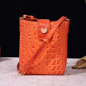 Detalle del bolso bandolera naranja vibrante con textura de patrón de cocodrilo vintage
