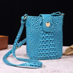 Bolso bandolera azul elegante con diseño de cocodrilo y detalles dorados.