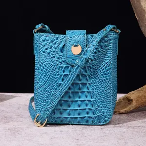 Vista detallada de la textura de cocodrilo azul claro en bolso bandolera para móvil