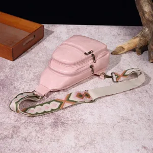 Vista macro detallada de un bolso de pecho retro rosa para mujer con correa tejida bohemia