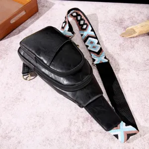 Detalle de bolso de pecho en cuero negro con correa tejida de estilo bohemio
