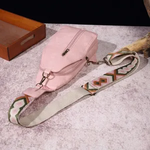 Bolso bandolera rosa vintage con correa bohemia sobre mármol