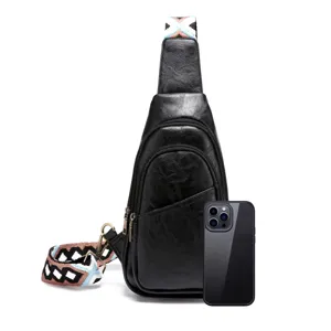 Bolso bandolera de cuero PU negro con correa bohemia y smartphone para comparar tamaño.