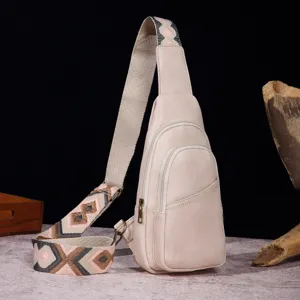 Elegante bolso bandolera retro crema con correa bordada bohemia sobre fondo de madera rústica.