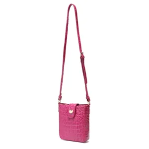 Vista lateral detallada del bolso bandolera fucsia con grabado de piel de cocodrilo
