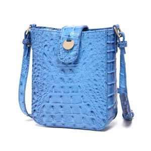 Vista frontal de bolso bandolera azul vintage motivo cocodrilo con cierre dorado