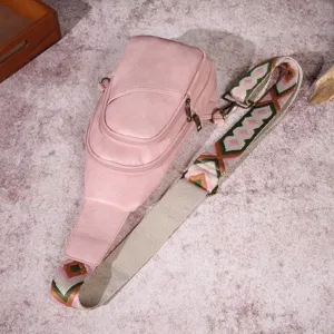 Detalle de bolso de pecho rosa con correa ancha de estilo bohemio tejido a mano