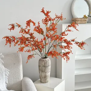 Orquídeas artificiales naranjas en un jarrón de piedra texturizado para el hogar
