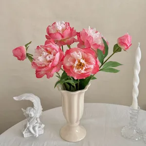 Detailansicht künstlicher rosa Pfingstrosen in Keramikvase mit eleganter Dekoration
