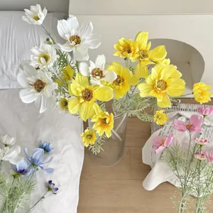 Detail view of multi-colored artificial cosmos flowers arranged in a glass vase