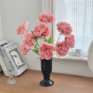 Close-up detail of pink silk peony flowers in a black fluted vase for elegant home decor