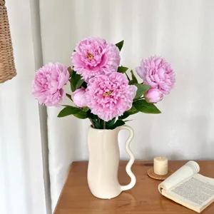 Realistic pink artificial peony bouquet displayed in a minimalist white wavy vase.