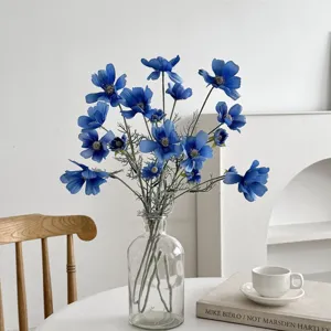 Elegant blue artificial cosmos flowers in a clear glass vase for home dining table decor