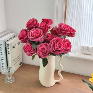 Gros plan de roses Corolla artificielles de style peinture à l'huile dans un vase blanc.