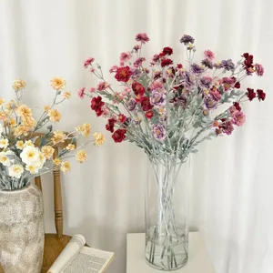 Detail view of vibrant flocked artificial camellia flowers in a modern glass vase