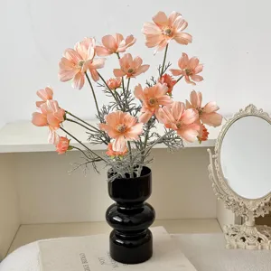 Realistic peach artificial cosmos flowers in a glossy black vase for home tabletop decor