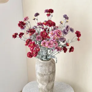 Detailed view of flocked artificial camellia bouquet in a rustic textured vase for home decor