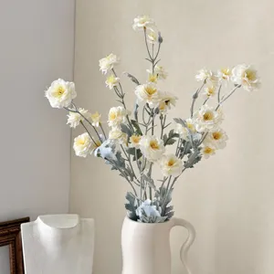 Elegant detailed view of cream white flocked artificial camellia flowers in a ceramic vase