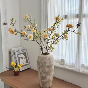 Detailed view of vintage autumn wild daisy artificial flowers displayed in a stone vase