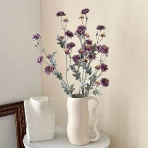 Elegant purple flocked artificial camellia flowers displayed in a modern ceramic vase